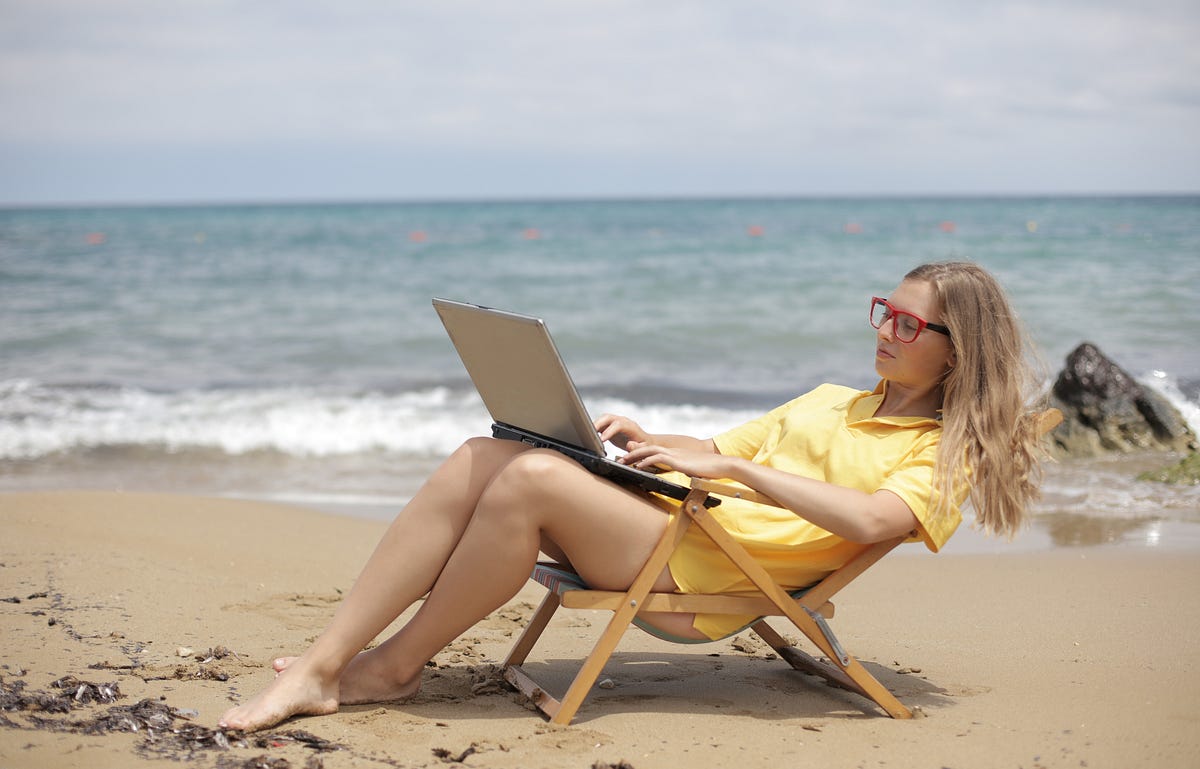 Image of business woman on the beach with her laptop